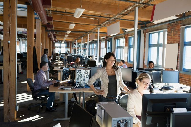 Business women viewing computer screen in open office